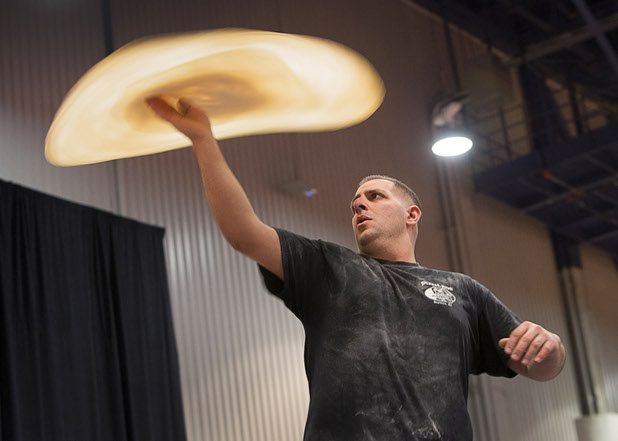 Joe Montuori of PizzaLinos in Bayonne, N.J., competes in the World Pizza Games Freestyle Acrobatic Dough Tossing event at the International Pizza Expo on Tuesday, March 8, 2016, in the Las Vegas Convention Center.