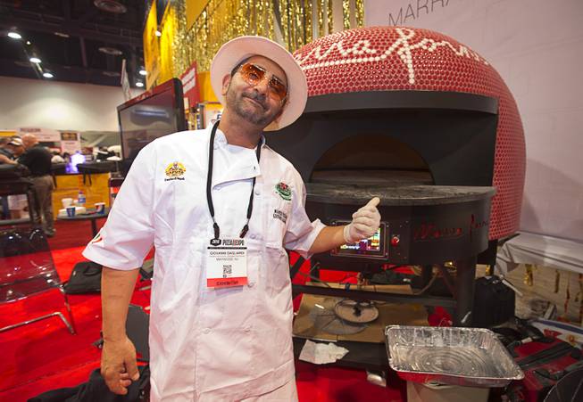 Giovanni Gagliardi poses in front of a Marra Forni pizza oven during the 2016 International Pizza Expo at the Las Vegas Convention Center Tuesday, March 8, 2016. The rotating ovens have a touch-screen LCD to easily change the rotation cycle, speed and direction.