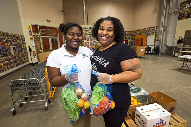 Volunteers Kymistry Towns and her mom Yasmin Dixon bag produce for the Senior Share program at Three Squares north campus, 4220 N. Pecos Rd., Wednesday, March 16, 2016.