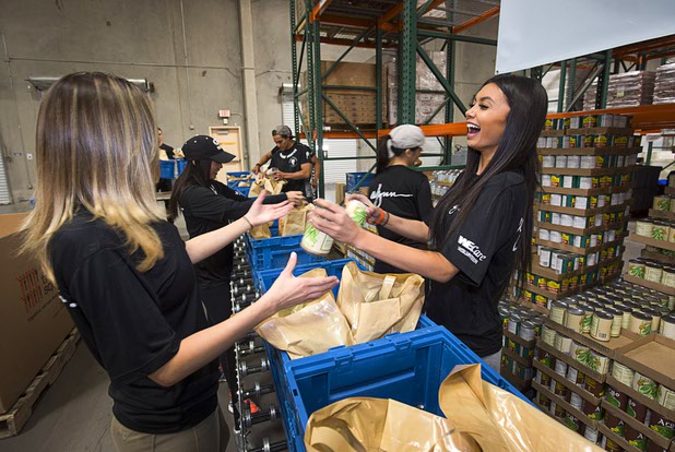 Cocktail servers Ekaterina Shestakova, left, and Luann Pagillo help assemble meals for mobile food pantries as employees from XS Nightclub and Encore Beach Club volunteer at Three Squares north campus, 4220 N. Pecos Rd., Wednesday, March 16, 2016.