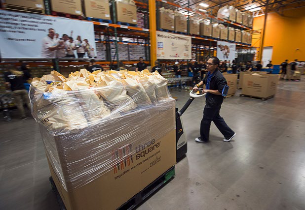 A worker moves bags a of meals assembled for mobile food pantries at Three Squares north campus, 4220 N. Pecos Rd., Wednesday, March 16, 2016.