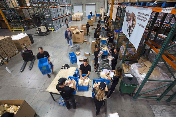 Volunteers from XS Nightclub and Encore Beach Club assemble meals for mobile food pantries at Three Squares north campus, 4220 N. Pecos Rd., Wednesday, March 16, 2016.