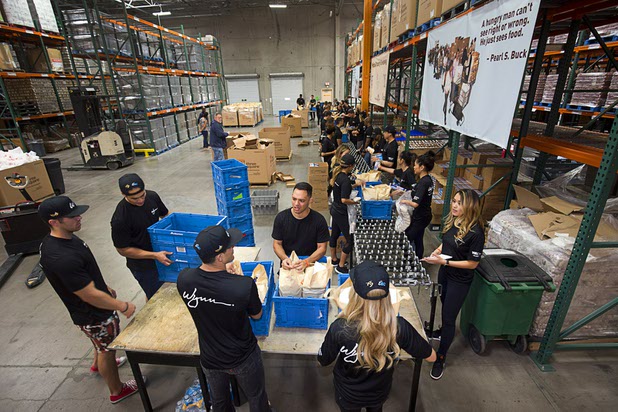 Volunteers from XS Nightclub and Encore Beach Club assemble meals for mobile food pantries at Three Squares north campus, 4220 N. Pecos Rd., Wednesday, March 16, 2016.