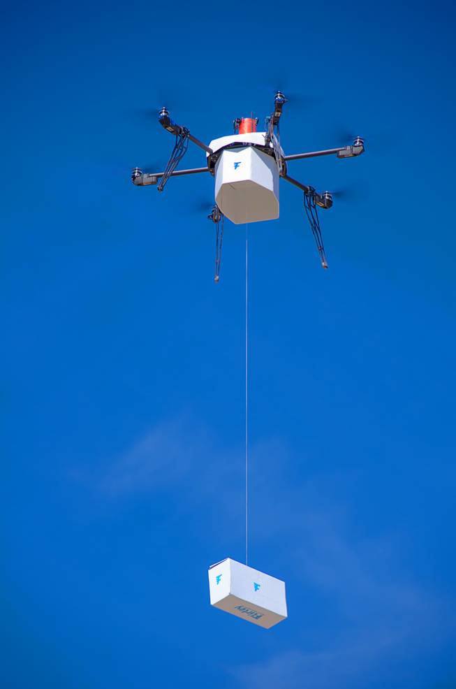 In this Friday, March 25, 2016, photo provided by Flirtey, an independent drone delivery company, shows the first fully autonomous, FAA-approved urban drone delivery, a box with bottled water, emergency food and a first aid kit in a residential setting without the help of a human to manually steer it in Hawthorne, Nev.