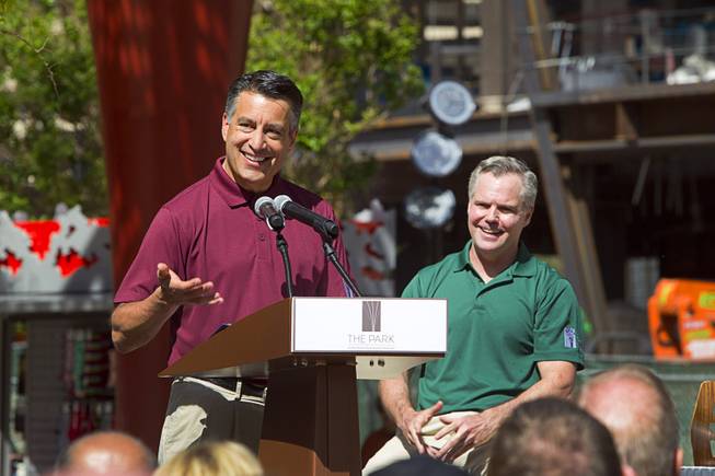 Nevada Governor Brian Sandoval, speaks during the grand opening of The Park Monday, April 4, 2016. MGM Resorts International Chairman/CEO Jim Murren listens at right. The new pocket park, lined with restaurants and seating for outdoor dining, runs from the Las Vegas Strip to the new T-Mobile Arena.