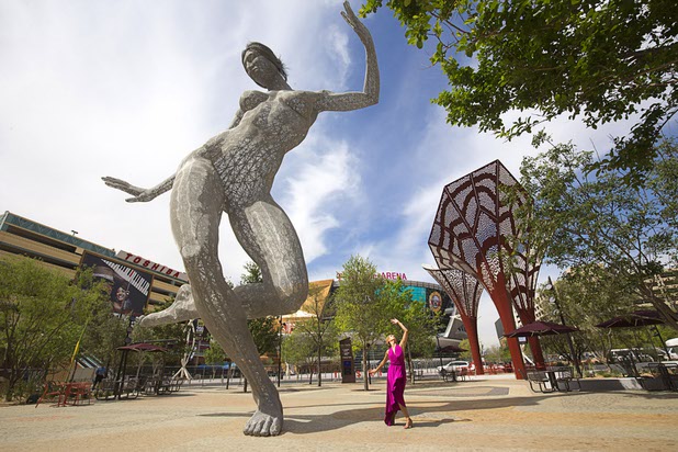 A dancer performs by Bliss Dance, a sculpture of a dancing woman created by artist Marco Cochrane, is shown during the grand opening of The Park Monday, April 4, 2016. The new pocket park, lined with restaurants and seating for outdoor dining, runs from the Las Vegas Strip to the new T-Mobile Arena.