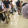 In this Aug. 3, 2015 file photo, with only open windows and fans to cool the room down, students enter their non air conditioned classroom at Campbell High School in Ewa, Hawaii.