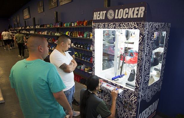 Shoppers try their luck at a sneaker machine, at $5.00 per try, at Urban Necessities in the Boulevard mall Sunday, April 17, 2016.