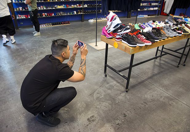 A shopper takes photos of sneakers at Urban Necessities in the Boulevard mall Sunday, April 17, 2016.