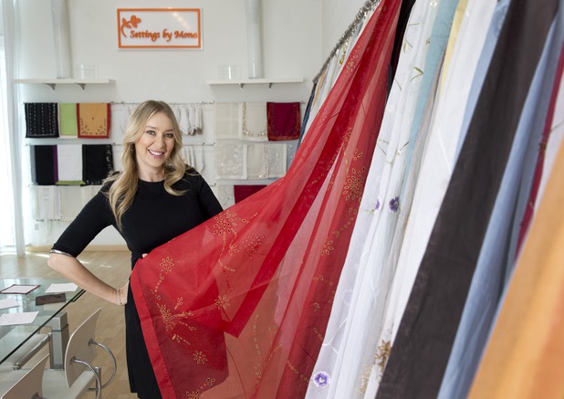Mona Steck, owner of Settings by Mona, a luxury linen company that specializes in hand embroidered/tailored table and bed linens, poses in her showroom Wednesday, April 27, 2016.