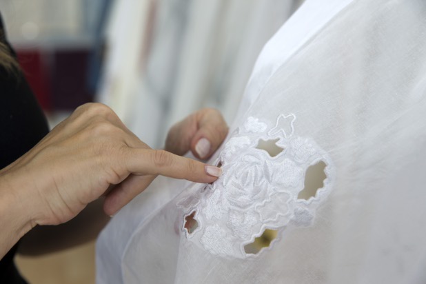 Mona Steck, owner of Settings by Mona, points out the hand-crafted detail of a table linen in her showroom Wednesday, April 27, 2016.