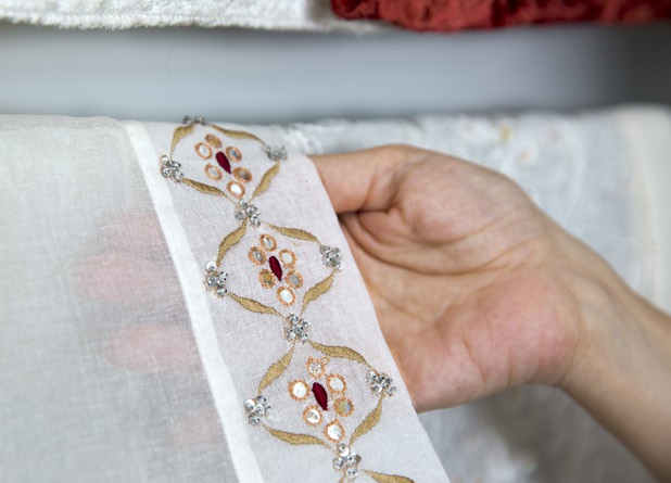 Mona Steck, owner of Settings by Mona, displays the hand-crafted work that is put into a table runner in her showroom Wednesday, April 27, 2016.