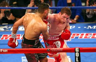 Canelo Alvarez, left, of Mexico hits Amir Khan of England with a knockout punch in the sixth round of their WBC middleweight title fight at the T-Mobile Arena Saturday, May 7, 2016.