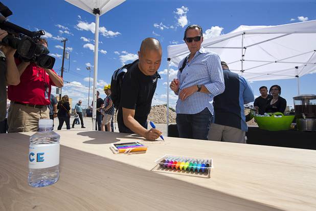 Tony Hsieh, left, CEO of Zappos, and Fred Mossler of Zappos and the Downtown Project, sign panels during groundbreaking ceremony for Fremont9, a new apartment complex at East Fremont and Ninth streets, in downtown Las Vegas, Monday, May 16, 2016. The panels will be used in the apartment construction.