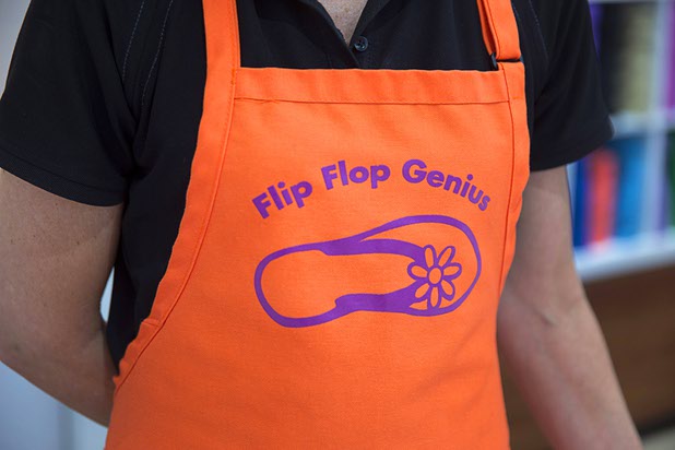 Shaunna Fisk, regional manager for Flip Flop Workshop, wears her "flip-flop genius" apron at the Fashion Show mall kiosk location Monday, May 23, 2016. The company allows you to decorate your flip-flops, then watch a flip-flop genius put it together in front of you.