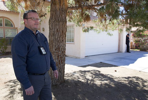Code enforcement officer Matthew Meanea stands outside a home that had been occupied by squatters in North Las Vegas Wednesday, May 18, 2016.