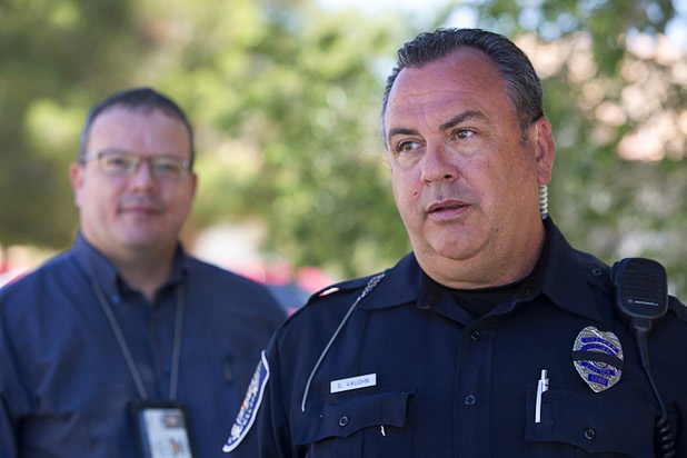 North Las Vegas Police Officer Scott Vaughn speaks outside a home that had been occupied by squatters in North Las Vegas Wednesday, May 18, 2016. North Las Vegas code enforcement officer Matthew Meanea is at left.