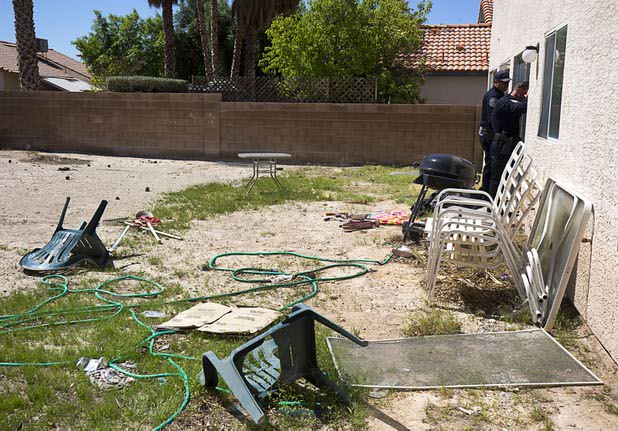 Police officers peek into a vacant North Las Vegas home that had been occupied by squatters, Wednesday, May 18, 2016. A new legislative measure aims to help authorities combat squatters.