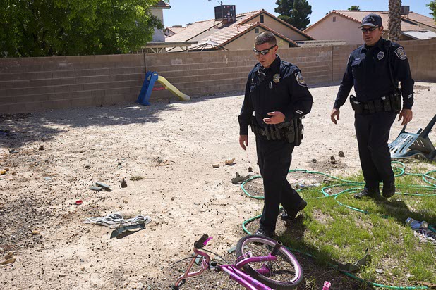 NHP Trooper Jason Buratczuk, left, and North Las Vegas Police officer Joshua Leavitt walk through the backyard of a vacant home that had been occupied by squatters in North Las Vegas Wednesday, May 18, 2016. Buratczuk happens to live in the neighborhood and stopped by to take a look, he said.