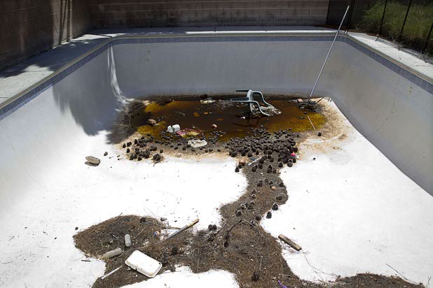 A backyard pool is shown at a vacant home that had been occupied by squatters in North Las Vegas Wednesday, May 18, 2016.