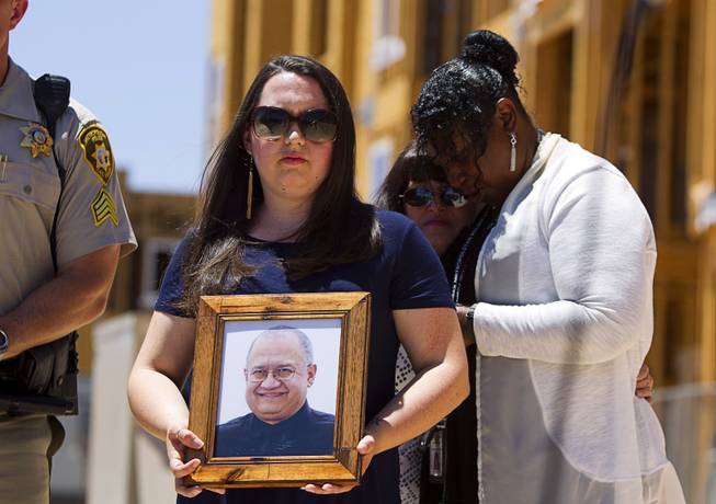 Amber Santee holds a photo of her father, Mark Santee, during a Metro Police news conference Wednesday, June 1, 2016, by an apartment complex under construction at Jerry Tarkanian Way and Hacienda Avenue. Security guard Mark Santee was shot and killed at the site in April. In the background, Metro Police’s victim advocate Regina Porter, right, stands with Amber’s mother, Nicole Santee.