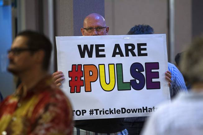 Mike Dini holds a sign during a vigil and call to action at the Gay & Lesbian Community Center of Southern Nevada on Sunday, June 12, 2016, in Las Vegas.
