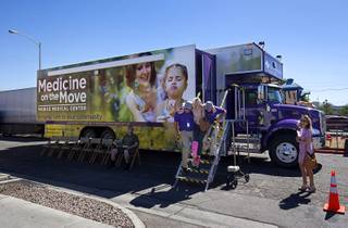 Patient Christy Miller is helped down the stairs from the Medicine on the Move mobile clinic at the Las Vegas Rescue Mission Wednesday, June 15, 2016. The clinic is from Southwest Medical, part of OptumCare, in partnership with Health Plan of Nevada and Sierra Health and Life.
