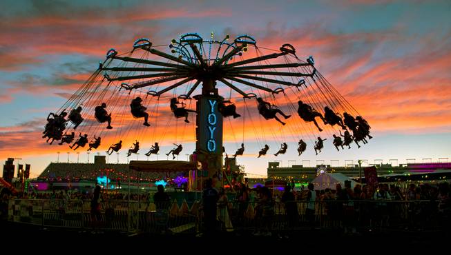 Riders on the YoYo carnival ride are silhouetted by a striking sunset during the first night of the Electric Daisy Carnival on Friday, June 17, 2016, at Las Vegas Motor Speedway.