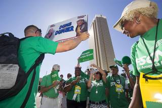 Brian Poncin of Chicago, a member of the American Federation of State, County and Municipal Employees (AFSCME) union, Local 2858, holds a sign with images of Republican presidential candidate Donald Trump and running mate Indiana Gov. Mike Pence during a picket at the Trump International Hotel Wednesday, July 20, 2016. AFSCME members, in Las Vegas for a convention, came out in support of the Culinary Workers Union, Local 226, which is trying to unionize workers at the hotel.