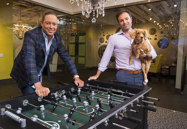 Eric Cohen, left, and Douglas Eisner, managing directors of the Calida Group, pose in the company's offices Thursday, July 21, 2016. Eisner holds his dog Penelope, a 3-year-old Cavalier Spaniel-poodle mix.