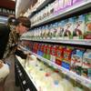 In this May 23, 2014 file photo, grocery and dairy assistant Reyna DeLoge stocks dairy products that only use milk from pasture-raised cows, at Vitamin Cottage Natural Grocers, in Denver. As Americans continue turning away from milk, an industry group is pushing back at its critics with a social media campaign trumpeting the benefits of milk. 