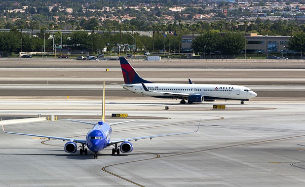 A Delta passenger jet taxis to a runway as a Southwest Airlines jet heads to a gate at McCarran International Airport Tuesday, August 2, 2016.
