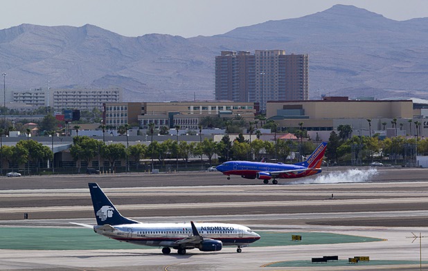 An Aeromexico passenger jet taxis to a runway as a Southwest Airlines jet lands at McCarran International Airport Tuesday, August 2, 2016.