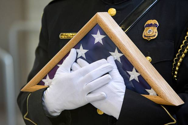 A member of the Homeland Security Investigations Honor Guard holds a flag during an opening ceremony for the Federal Justice Tower, a new office building in downtown Las Vegas, Thursday, Aug. 18, 2016. The flag, which has been flown over the capital in Washington D.C., was presented to the family of developer Stephen Biagiotti. Stephen Biagiotti, founder of SDA Inc., died in 2015 before the completion of the building.