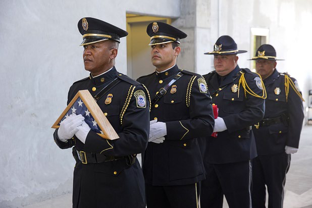 A member of the Homeland Security Investigations Honor Guard holds a flag during an opening ceremony for the Federal Justice Tower, a new office building in downtown Las Vegas, Thursday, Aug. 18, 2016. The flag, which has been flown over the capital in Washington D.C., was presented to the family of developer Stephen Biagiotti. Stephen Biagiotti, founder of SDA Inc., died in 2015 before the completion of the building.