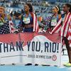 The United States' Courtney Okolo, Natasha Hastings, Phyllis Francis and Allyson Felix hold a sign and wear their nation's flag Saturday, Aug. 20, 2016, after winning the gold in the women's 4x400 meter relay during the Summer Olympics inside Olympic stadium in Rio de Janeiro.