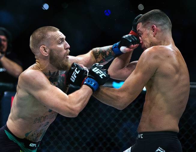 Welterweight Conor McGregor strikes Nate Diaz squarely on the nose during their UFC 202 fight night action at the T-Mobile Arena on Saturday, August 20, 2016.