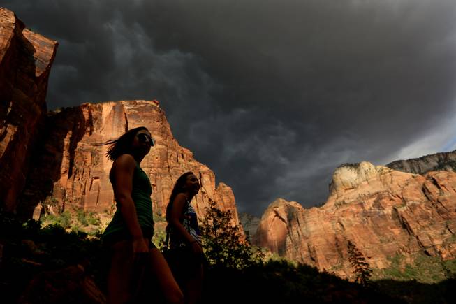 Hikers look up at a fast-moving storm as it makes its way through Zion National Park outside of Springdale, Utah.
