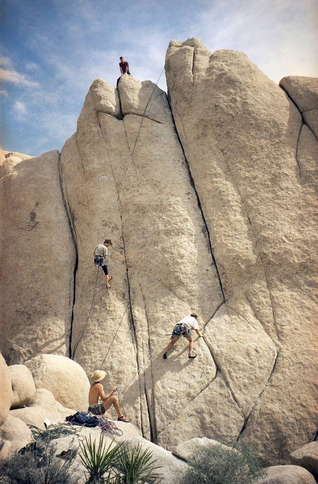 A Swedish climber rappels off one climb, left, as a team of Arizona climbers work on a zigzag crack in Joshua Tree National Park, Calif., Tuesday, April 20, 1999. (AP Photo/Martha Bellisle)