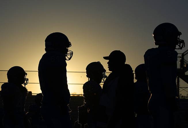Canyon Springs players are silhouetted against the sunset as they warm up for a home game against visiting Basic on Friday evening, Sept. 23, 2016.