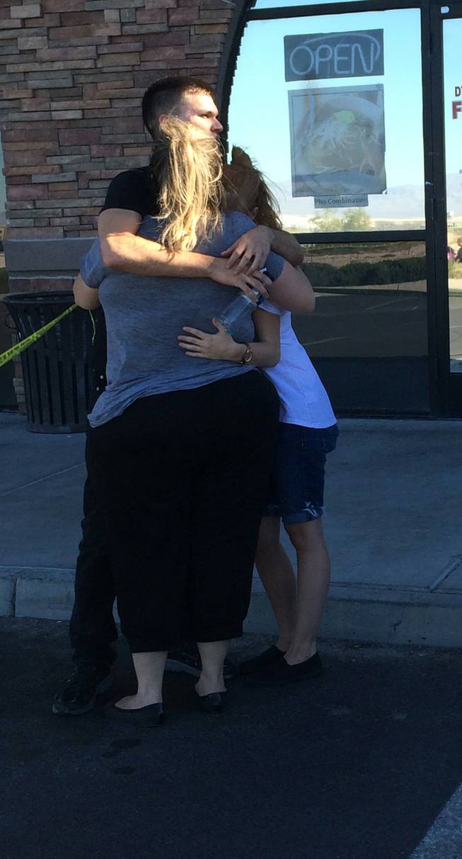 Will Wright, center, hugs his mother, Kristina Gebers, left, and his sister following a shooting at Starbucks, 7260 S. Rainbow Blvd. #100, on Sunday, Sept. 25, 2016. Wright, a cashier at Starbucks who was working at the time of the incident, talked to his mom on the phone for about an hour as he barricaded himself and two others in a room at the back of the coffee shop after a man opened fire.