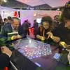 People try out a "Brew Caps" game at the Gamblit booth during the Global Gaming Expo (G2E) convention at the Sands Expo and Convention Center Tuesday, Sept. 27, 2016.