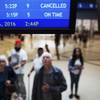 Travelers look at an arrival board displaying a flight cancellation at Hartsfield-Jackson Atlanta International Airport in Atlanta, Thursday, Oct. 6, 2016. Airlines canceled hundreds of flights for Thursday and again Friday as Hurricane Matthew pelted the Florida coast with high winds and heavy rain. (AP Photo/David Goldman)