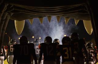 Las Vegas players emerge from their Wildcat tunnel past the smoke onto the field to face Canyon Springs in their game on Friday, Oct. 7, 2016.
