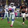 Dallas Cowboys running back Ezekiel Elliott, center, approaches the end zone after a long run for a touchdown as Cincinnati Bengals free safety George Iloka, right, gives chase in the second half of an NFL game Sunday, Oct. 9, 2016, in Arlington, Texas.