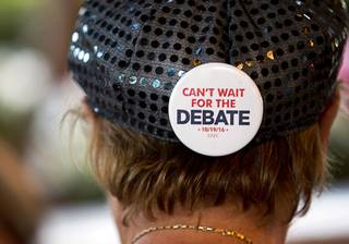 Patty Freese, a supporter of Republican presidential nominee Donald Trump, wears a button promoting the Oct. 19 debate at UNLV as she joins other supporters outside the Trump International Hotel in Las Vegas Tuesday, Oct. 18, 2016.