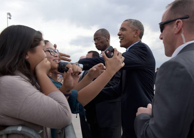 President Barack Obama greets people Sunday, Oct. 23, 2016, after arriving at McCarran International Airport. Obama is in Nevada to boost Hillary Clinton's presidential campaign and help Democrats in their bid to retake control of the Senate. 