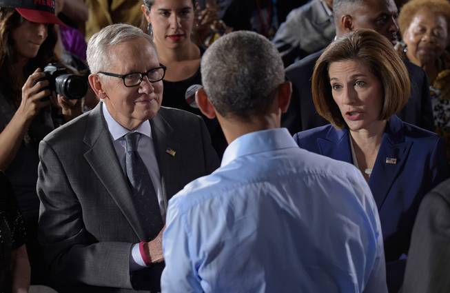 President Barack Obama, center, talks with Democratic Senate candidate Catherine Cortez Masto, right, and Senate Minority Leader Harry Reid of Nevada after speaking at Cheyenne High School in North Las Vegas on Sunday, Oct. 23, 2016, at a campaign event for Democratic presidential candidate Hillary Clinton and Cortez Masto. Obama was in Nevada to boost Clinton's presidential campaign and help Democrats in their bid to retake control of the Senate. 