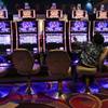 In this Oct. 3, 2014, file photo, a visitor to the Resorts World Casino at the Aqueduct racetrack plays an electronic slot machine, in the Queens borough of New York.