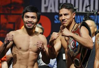 Manny Pacquiao, left, of the Philippines, and Jessie Vargas pose during a weigh-in, Friday, Nov. 4, 2016, in Las Vegas. The two are scheduled to fight in a welterweight title bout Saturday in Las Vegas.
